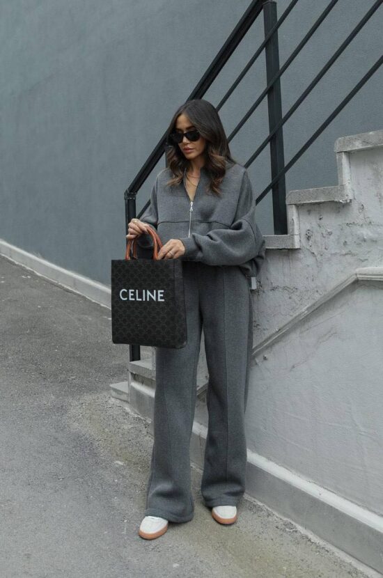 A woman wearing the Zae Casual set, consisting of grey wide leg pants and a black tote bag.