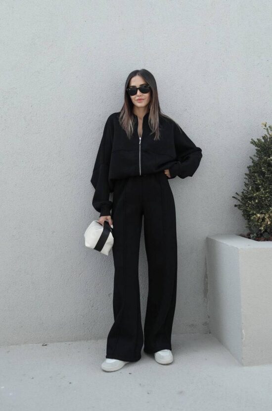 Zae, a woman wearing a casual set consisting of a black jacket and wide leg pants.